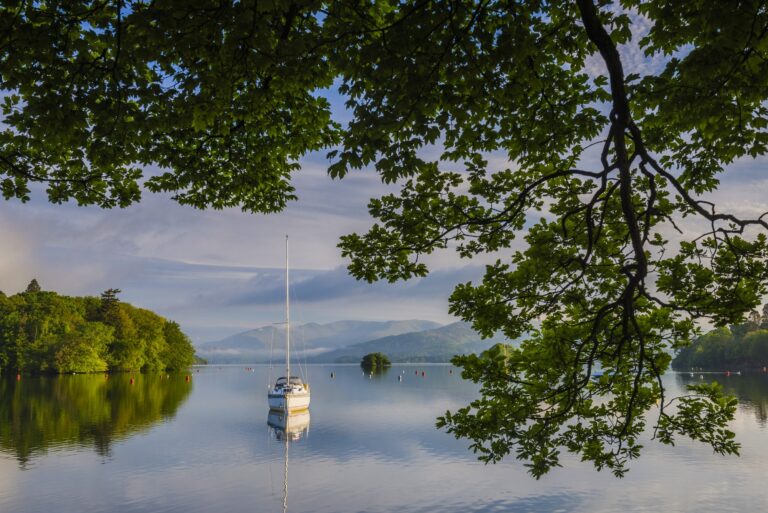 Sailing boat floating on Lake Windermere at sunrise, Lake District National Park Landscape, Cumbria,