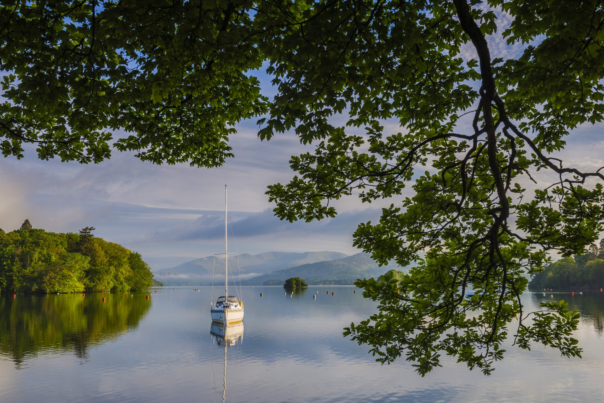 Sailing boat floating on Lake Windermere at sunrise, Lake District National Park Landscape, Cumbria,