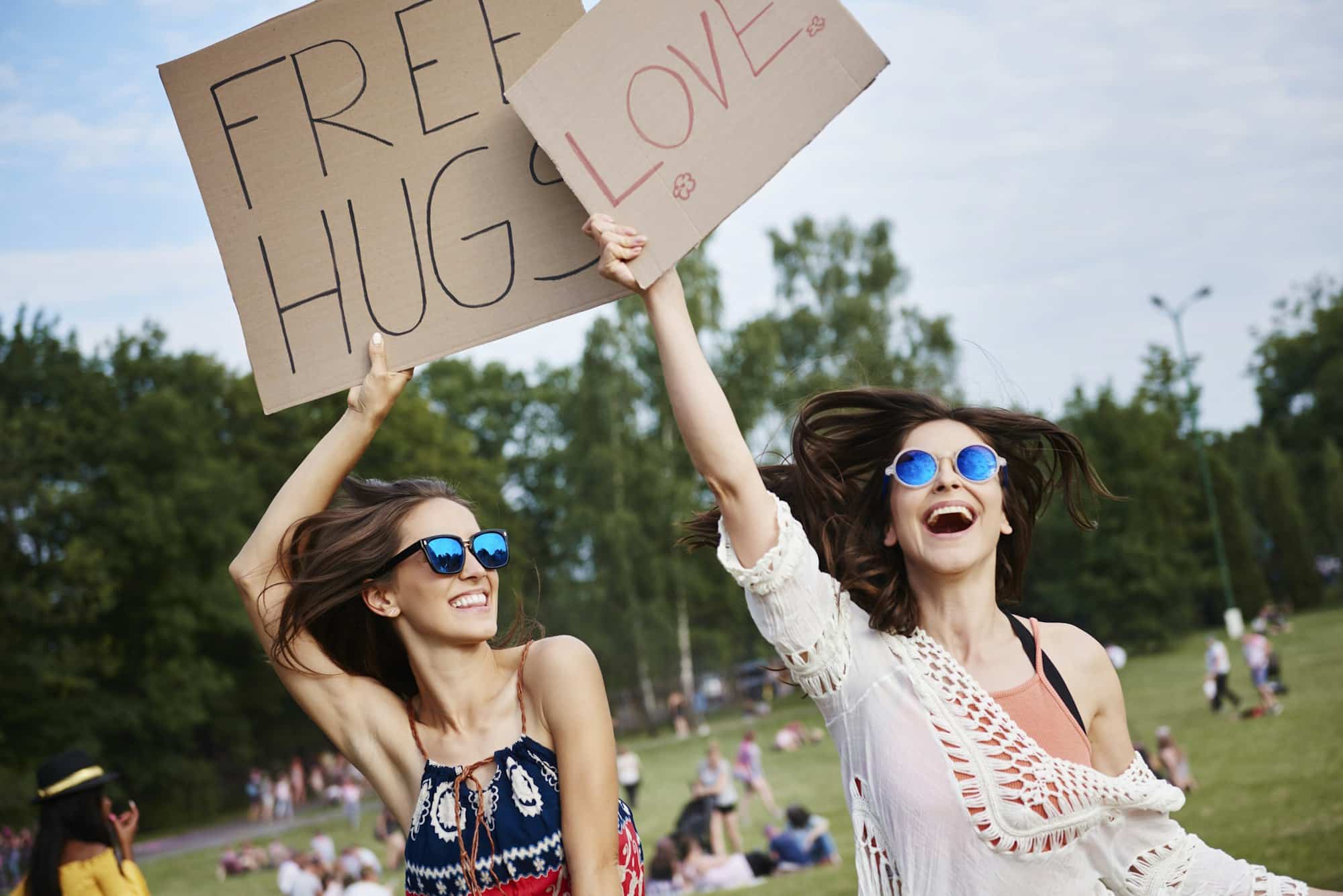 Friends holding up cardboard signs at music festival